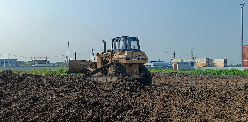 Бульдозер и экскватор роют и копают котлованы в Черногорске